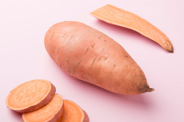 Sweet potato vegetable on a pink background. Sliced ​​sweet potato. In the context.