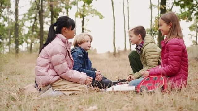 Smiling multinational group of children talking at picnic time