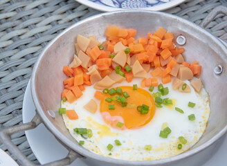 Kai ka tha or Fried Egg in Soy Sauce with Sausage and Carrots in pan. Simple Thai breakfast.