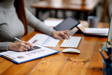 Financial Businesswomen analyze the graph of the company's performance to create profits and growth, Market research reports and income statistics, Financial and Accounting concepts.