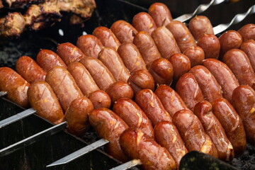 Sausages are roasted on the grill in the open air. Sausages are traditionally prepared at all gastronomic festivals. Very hearty and tasty dish. Street picture of food
