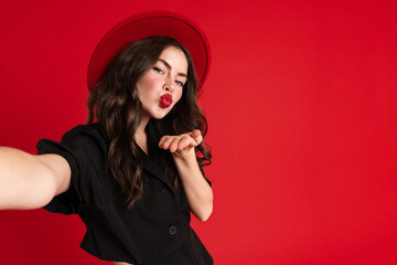 White young woman taking selfie photo while blowing air kiss