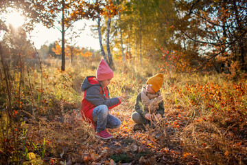 Happy two siblings have rest in beautiful forest during autumn walk. Young explorers, fall...