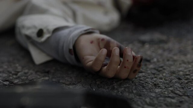 Close up of child hand in blood on road after car accident