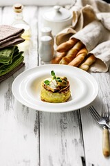 Delicious vegetarian muffin with zucchini and blue cheese on a white plate. Grissini Italian breadsticks with cheese. Tasty and healthy food. Restaurant serving and dish decoration. Copy space