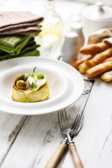 Delicious vegetarian muffin with zucchini and blue cheese on a white plate. Grissini Italian breadsticks with cheese. Tasty and healthy food. Restaurant serving and dish decoration. Copy space