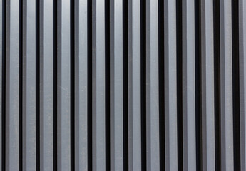 Corrugated sheet metal, badly painted with gray paint for background. Metal corrugated roofing sheet.Painting of metal surfaces for rust control Abstract background for sites and layouts. Iron fence