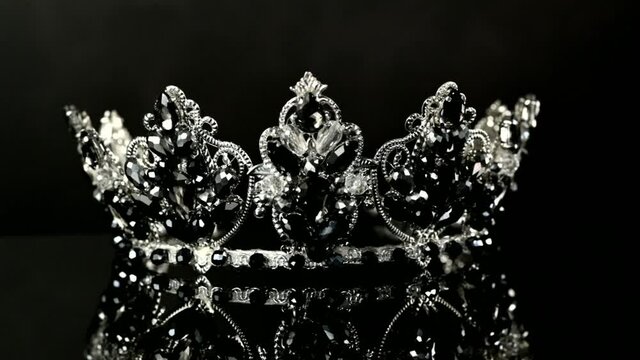 beautiful crown of white metal and black stones on a black background