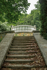 old stone staircase in an abandoned park. Fallen leaves lie on old steps and railings of stairs. concept is abandoned architecture of city.