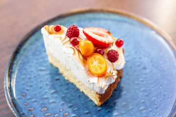 triangular piece of fresh diet dessert cake made of delicious cream and frozen fruits and berries. Raw food cake dessert. concept is vegetarian desserts.