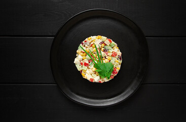 crab stick salad with corn and vegetables, on a black wooden table,horizontal, no people,