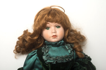 Portrait of vintage dolls wearing a green medieval dress on white background