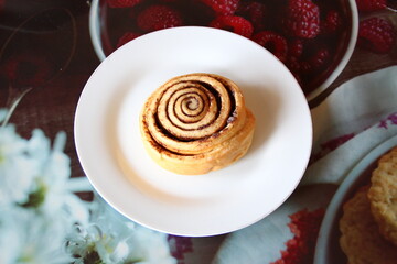 Appetizing cinnamon roll on a white plate