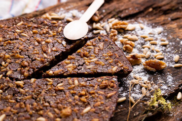 close up of traditional castagnaccio cake slice, a classic italian gluten free autumn cake on wooden table made with chestnuts flour, pine nuts, rosemary and olive oil. italian bakery healthy food.