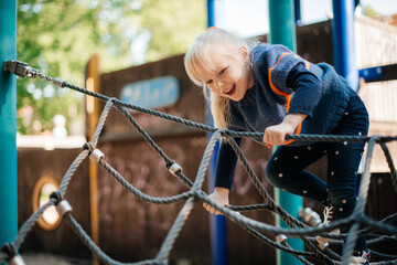 
little blonde girl having fun on the playground