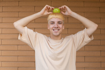 Healthy eating, fruits and people concept - Smiling blond Caucasian man dressed in a beige T-shirt,...