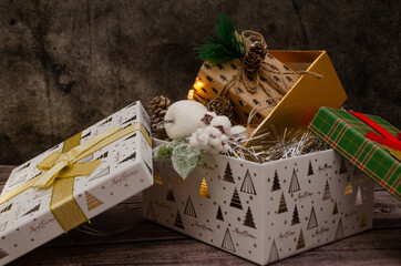 boxes with christmas toys and garland on a wooden table, holiday atmosphere