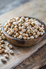 Raw chickpeas in a wooden bowl. Legume dietary fibers and vegetable protein for healthy eating.