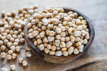 Raw chickpeas in a wooden bowl. Legume dietary fibers and vegetable protein for healthy eating.