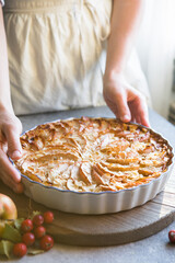 Homemade apple pie surrounded by red apples