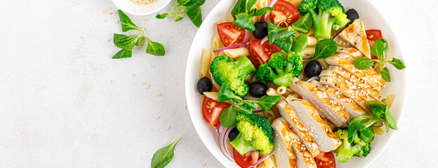 Banner. Pasta salad bowl with broccoli, tomato, onion, olives, corn salad and grilled chicken breast for lunch. Healthy dietary food. Top view. - obrazy, fototapety, plakaty