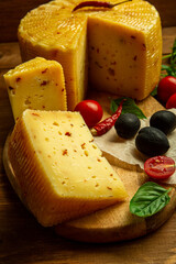 composition of different types of sliced cheese: hard, mature, cheese with mold. Cheese slicing with fruit - grapes and figs. concept is cheese handicraft production, restaurant.