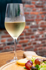 Naklejka premium Glass of cold white wine served on outdoor terrace in old French cafe