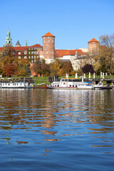 Wawel Royal Castle, view from the side of the Wisla river on an autumn day, barges and restaurants, Krakow, Poland