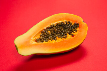 Papaya fruit on a orange background. Half papaya.