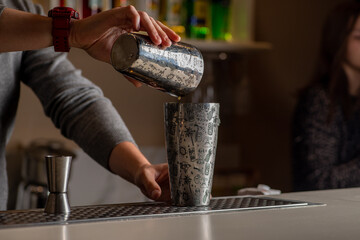 Bartender is preparing a cocktail at the bar.