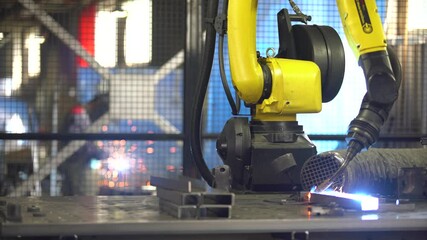 automatic welding by a robot at the factory, a man is working in the background - Powered by Adobe