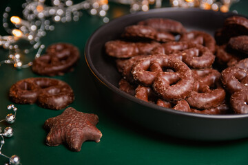 Close-up of chocolate gingerbread in a bowl, on green background.
