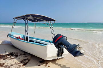Motorboat with canopy on a sandy beach on azure sea background. Holidays and travel on a paradise...
