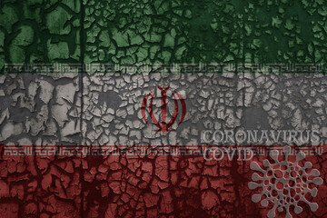 flag of iran on a old metal rusty cracked wall with text coronavirus, covid, and virus picture.