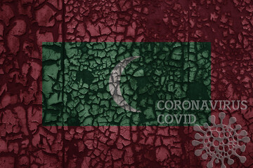 flag of maldives on a old metal rusty cracked wall with text coronavirus, covid, and virus picture.