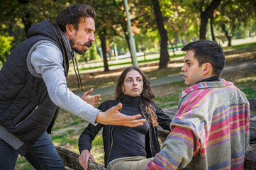 Fototapeta premium Three upset friends in fierce argument. Group quarrel concept