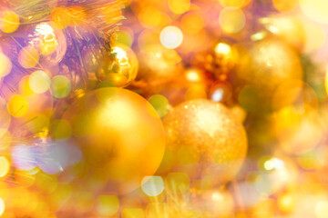 Obraz na płótnie Canvas Decorated with golden Christmas balls on a blurred and sparkling light background 