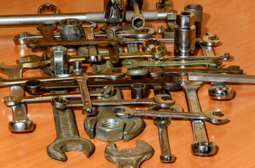 Various wrenches, heads, collars and nuts are laid out on a wooden table
