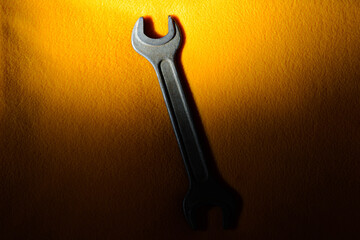 The horn wrench is partially illuminated on a yellow fabric background