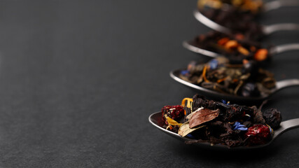 Various types of dry tea for a tea ceremony or tea drinking on a dark background. Tea concept, tea...