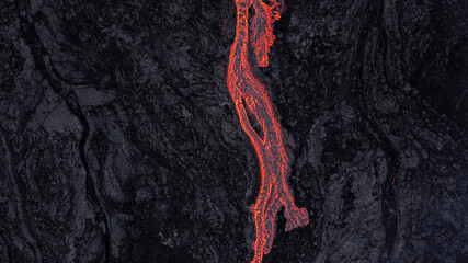 hot lava running on solidified black lava