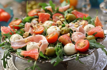 Salad with fruits, bacon and wine on a gray background