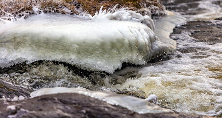 Fast river with ice and snow in late autumn
