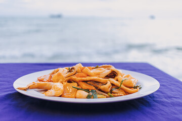 Thai Stir Fried Squid with Salted Egg Yolk served on blue table.