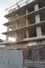 Construction of a new residential monolithic-frame house in the city using a truck crane in clear sunny weather