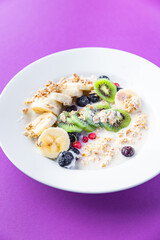 oatmeal bowl fruit banana, kiwi, berries, blueberries ready to eat meal snack on the table copy space food background rustic. top view keto or paleo diet