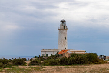 Fototapeta na wymiar Far de la Mola, a lighthouse on the southeastern tip of the island of Formentera in the Balearic Islands, Spain - White lighthouse on the top of a cliff in the Mediterranean Sea