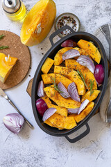Raw pumpkins slice with rosemary and purple onion, baking fresh healthy food with spice on a gray stone background. Keto or paleo diet veggie vegan or vegetarian. Top view flat lay background.