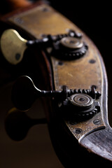 The tuning machine head with tuning keys or machine pegs of a acoustic wood double bass. A common instrument in classical and jazz music.
