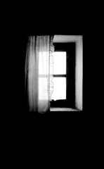 Window of old house with white curtain